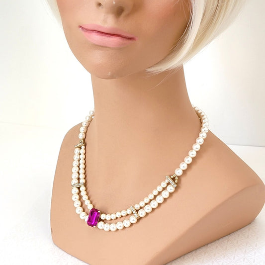 Vintage faux pearl necklace with rhinestones and magenta pink acrylic focal, displayed on a mannequin.