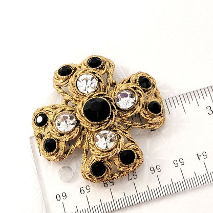 Large, textured gold tone Maltese cross rhinestone brooch, next to a ruler.