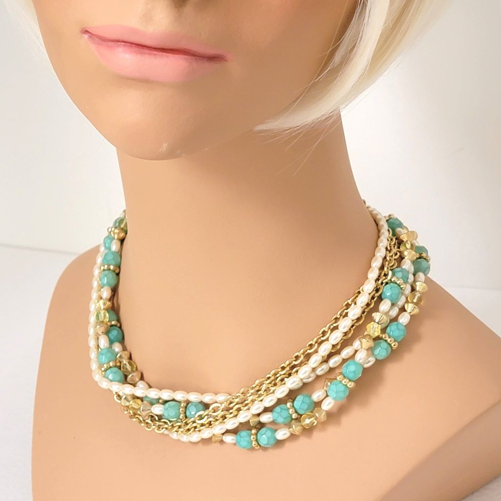 Sarah Coventry faux pearl and sea green, multistrand choker necklace, with gold tone chains. Shown on a mannequin.
