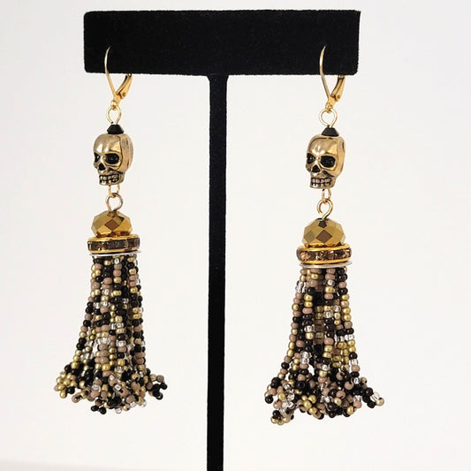 Extra-long gold tone skull dangle bead tassel earrings with rhinestones.