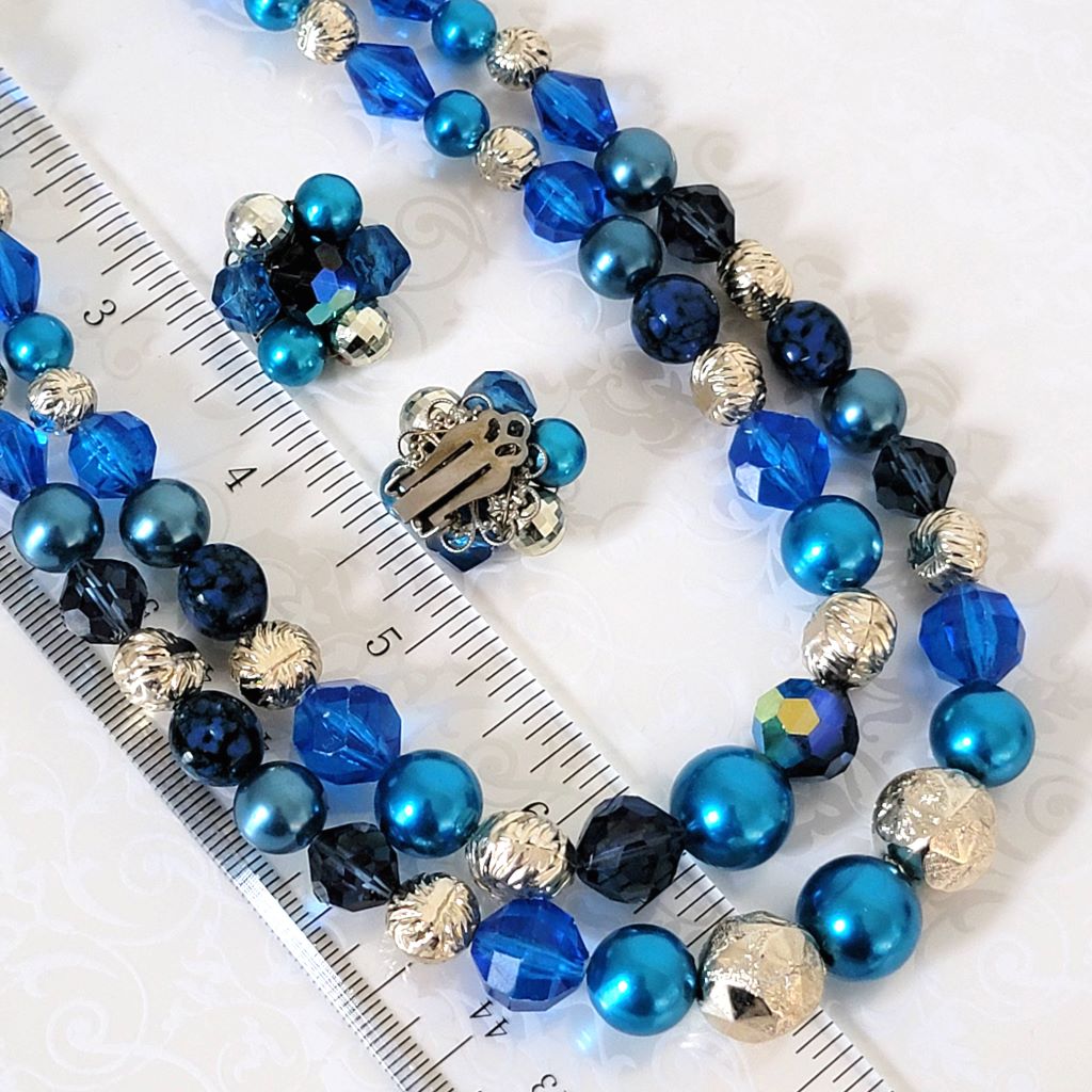 Vintage blue faux pearl choker and clip on earrings set, closeup view, next to a ruler.